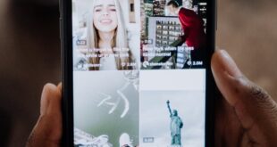 Close-up of a person using a smartphone to browse a social media app indoors.