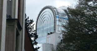 Striking modern architecture in Brussels featuring a futuristic dome and steel design.