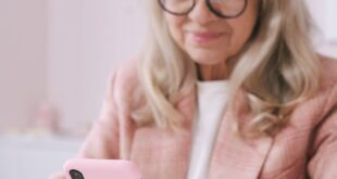 Elderly woman using smartphone at home. Technology and lifestyle concept.