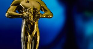 A shining Oscar statuette, symbolizing achievement in the film industry, against a vibrant blue backdrop.