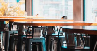 A vibrant and modern cafe setting featuring high stools and large windows in Accra, Ghana.