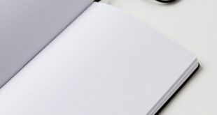 Minimalist open notebook with a ribbon bookmark on a table, ready for notes.