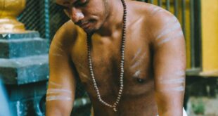 A man engaged in a cultural ritual in Kuala Lumpur showcasing traditional body art.