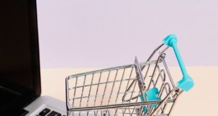 Mini shopping cart on a laptop symbolizes online shopping and e-commerce themes.