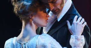 Romantic theatrical moment with actors embracing onstage.