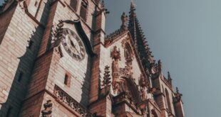 Explore the intricate Gothic architecture of Saint-Nizier Church in Lyon, France, under a bright sky.