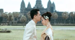 A couple in traditional Khmer clothing shares an intimate moment at Angkor Wat, Cambodia.
