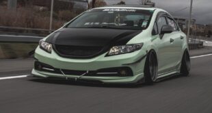 A customized Honda Civic sports car on a highway, showcasing its sleek design and performance.