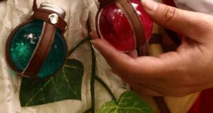 Close-up of fantasy costume with green and red potion bottles and ivy leaves.