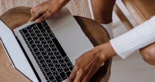 Close-up of a woman typing on a laptop indoors, focusing on technology and modern lifestyle.