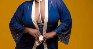 Stylish portrait of a woman in a blue robe with confident pose, set against a bold yellow background.