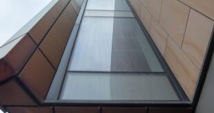 A striking view of contemporary architecture capturing geometric shapes and glass facade from below.