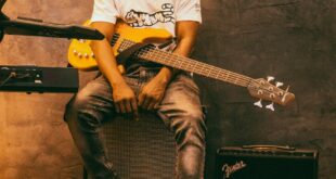 A stylish musician poses with an electric guitar indoors, in Accra, Ghana.