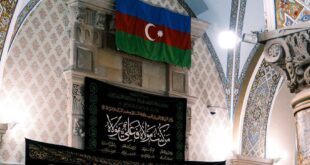 Intricate mosque interior featuring Azerbaijani flag and Islamic calligraphy.