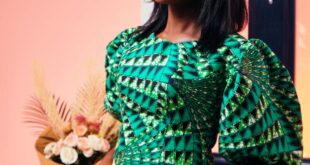 An elegant woman poses indoors wearing a green and yellow trendy outfit.