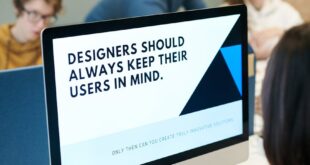 Group of designers collaborating in modern office space with computer.