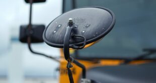 Close-up of a yellow school bus's mirror and front details in Kitchener, Ontario, Canada.