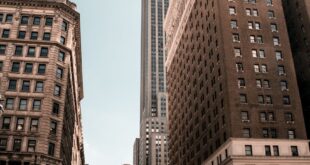 Bustling city life with iconic skyscraper under clear sky.