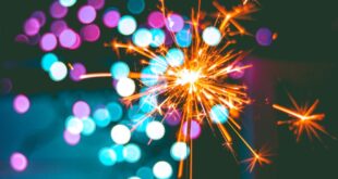 A dynamic sparkler igniting against a colorful bokeh background, perfect for celebrations.