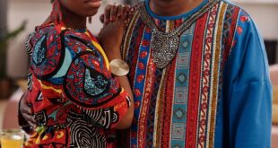 Couple embracing in vibrant African attire symbolizing culture and togetherness.