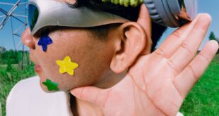 A man outdoors wearing headphones and fun accessories, gesturing with interest. Perfect for music or lifestyle themes.