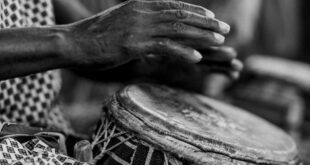 Close-up of a traditional drummer in Accra, Ghana, showcasing cultural heritage and music.