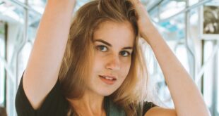 Woman posing inside a modern train, showcasing urban fashion and lifestyle.