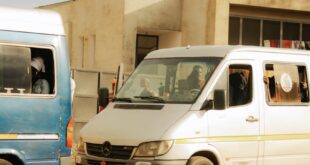 City street view featuring multiple vehicles in traffic, highlighting urban transportation.