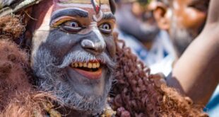 Captivating portrait of a man in traditional attire during Masaan Holi festival in Varanasi, India.
