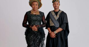 Elegant portrait of a couple in traditional African attire against a plain backdrop.