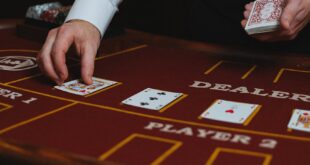 Dealer handling cards at a casino table during a game.