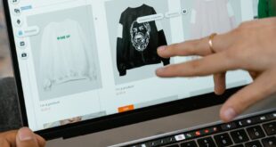 Close-up of hands interacting with a shopping website on a laptop screen indoors.