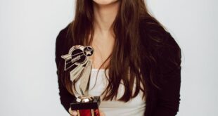 Joyful woman celebrating with a trophy, symbolizing achievement and success.