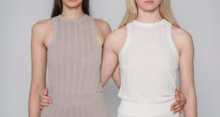 Studio shot of two women embracing in minimalist fashion attire.