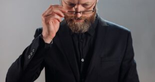 A priest in a cassock reading a book in a church, emphasizing devotion and spirituality.