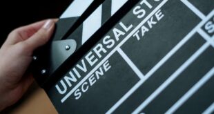 A detailed view of a Universal Studios clapboard held in hands, perfect for film industry concepts.