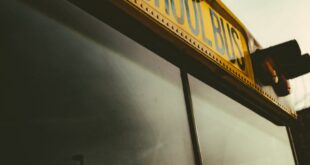 Dramatic low angle shot of a classic yellow school bus against a blue sky