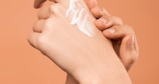 Close-up of hands applying moisturizer, promoting skincare and softness.